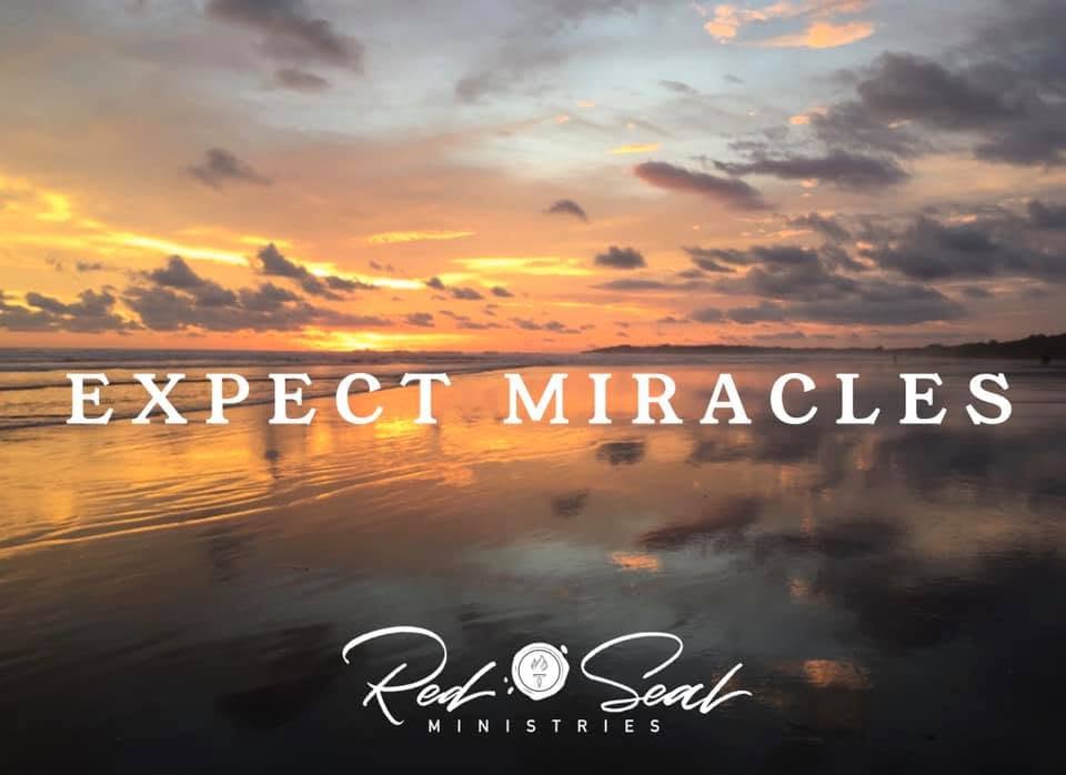 Sunset over the ocean at low tide with the words Expect Miracles and the Red Seal Ministries wordmark.